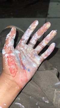 a person's hand with paint on it