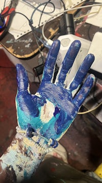 a person's hand with blue paint on it