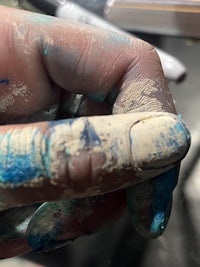 a person's hand with blue paint on it