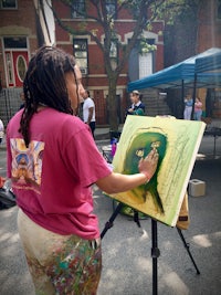 a woman painting on an easel