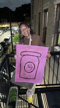 a girl holding a drawing on a balcony