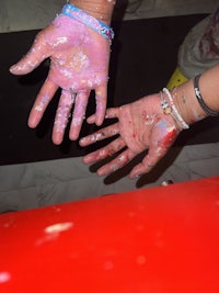 a person's hands are covered in paint