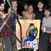 a group of people posing for a photo with a painting